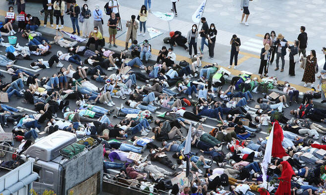 924 기후정의행진 참가자들이 지난 24일 서울시청 인근 세종대로에서 기후위기를 경고하며 드러눕는 ‘다이-인(Die-in)’ 시위를 하고 있다. 뉴스1