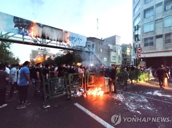 경찰과 충돌하는 이란 '히잡 미착용女 의문사' 항의 시위대 (테헤란 EPA=연합뉴스) 21일(현지시간) 이란 수도 테헤란에서 열린 마흐사 아미니(22) 의문사 규탄 시위 도중 시위대와 경찰이 충돌하고 있다. 지난 13일 히잡을 착용하지 않았다는 이유로 경찰에 구속된 아미니가 16일 사망했다고 발표되자 진상규명 요구 시위가 이란과 세계 각지에서 일어나고 있다. 이란 국영 통신 IRNA는 에브라힘 라이시 이란 대통령이 유가족에게 전화로 조의를 표했으며 고인의 죽음에 대한 진상 조사는 신중하게 진행될 것이라고 말했다고 전했다. 2022.9.22 alo95@yna.co.kr (끝)