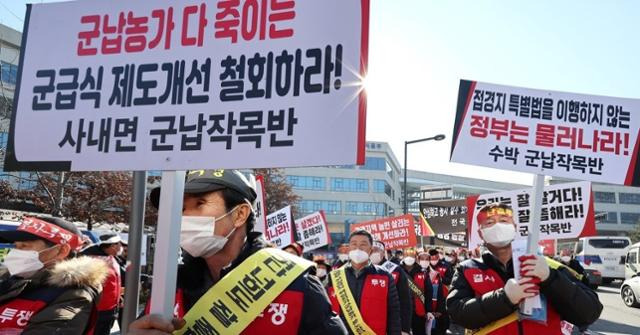 전국 군납농협과 농가 관계자들이 올해 1월 정부세종청사 농림축산식품부 앞에서 군 급식 경쟁입찰 도입 철회를 촉구하는 집회를 열고 구호를 외치고 있다. 연합뉴스