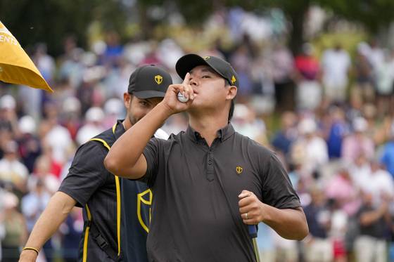 Sep 25, 2022; Charlotte, North Carolina, USA; International Team golfer Si Woo Kim (right) reacts after making his putt on the 15th green in front of caddie Manuel Villegas (left) during the singles match play of the Presidents Cup golf tournament at Quail Hollow Club. Mandatory Credit: Jim Dedmon-USA TODAY Sports 〈저작권자(c) 연합뉴스, 무단 전재-재배포 금지〉