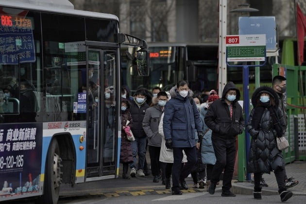 중국 베이징 외곽에서 마스크를 쓴 사람들이 버스 정류장에서 걸어나오고 있다. /사진=AP