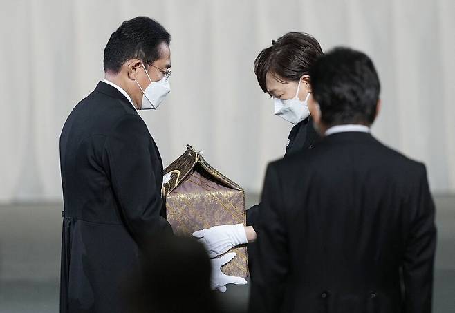 아베 신조 전 일본 총리의 국장이 열린 27일 도쿄 무도관에서 고인의 부인인 아베 아키에 여사(60·오른쪽)가 남편의 유골함을 기시다 후미오 총리(65)에게 전하고 있다. AFP 연합뉴스