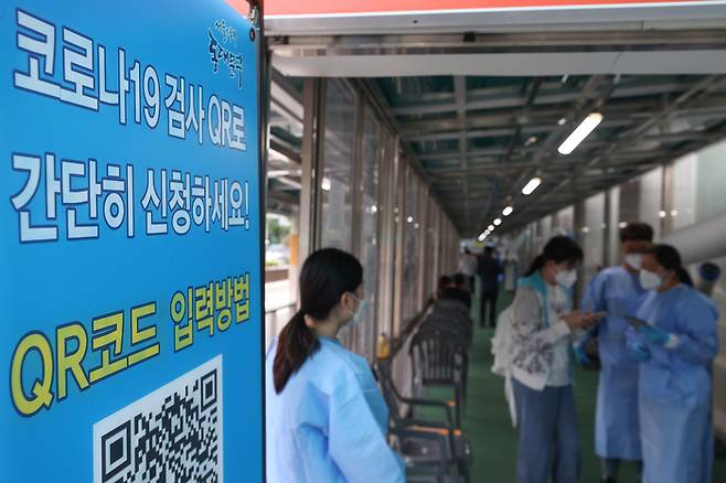 지난 26일 오전 서울 동대문구보건소에 마련된 선별진료소를 찾은 시민이 관계자의 안내를 받고 있다. 연합뉴스
