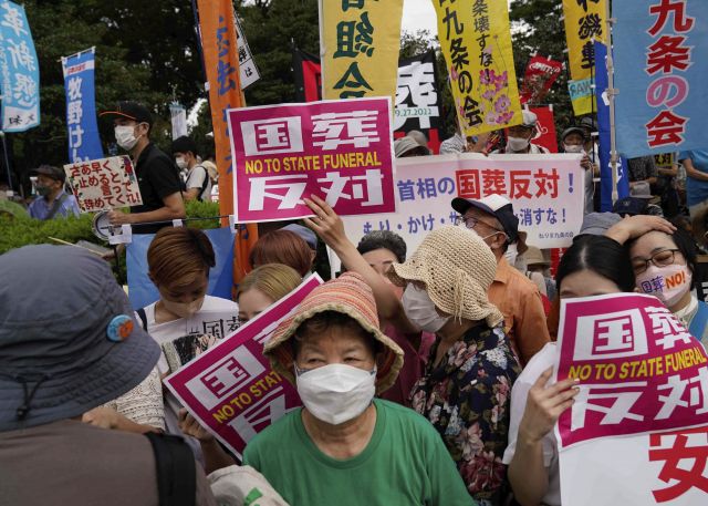 ‘국장 반대’를 적은 팻말을 든 일본 시민들이 27일 도쿄에서 행진하고 있다. AP뉴시스