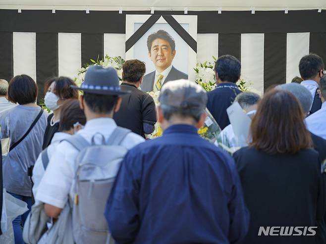 [도쿄=AP/뉴시스]27일 아베 신조 전 일본 총리의 국장이 치러지는 도쿄 니혼부도칸 인근에 일반 시민을 위한 헌화대가 설치됐다. 이날 오전 시민들이 꽃을 두고 조문하고 있다. 2022.09.27.