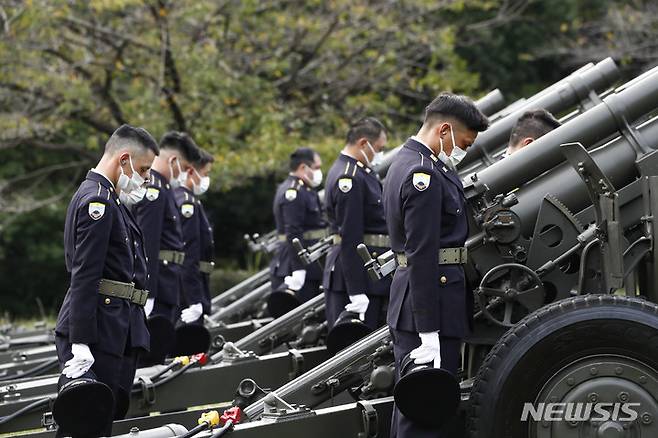 [도쿄=AP/뉴시스] 아베 신조 전 일본 총리의 국장이 열린 27일 도쿄의 닛폰부도칸에서 육상자위대 대원들이 조포를 발사한 후 묵념하고 있다. 자위대는 조의를 담아 19발의 조포를 발사했다. 2022.09.27.