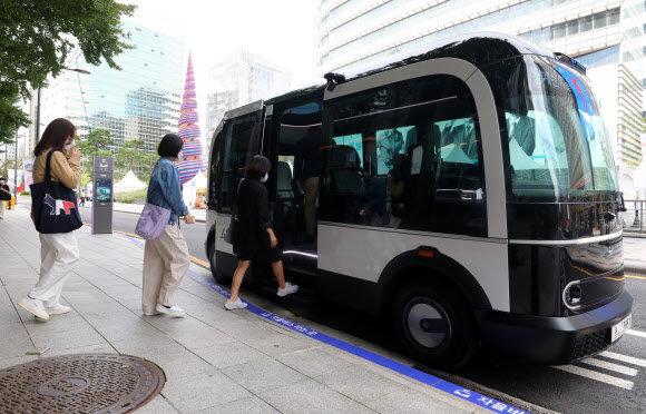 청계천로 자율주행 전용 셔틀버스 시범 운행이 시작된 26일 오전 서울 중구 청계천광장에서 서울시 관계자들이 차량에 오르고 있다. 다음달부터 3대의 셔틀버스가 정식 운행을 시작하며, 앱을 통해 이용할 수 있다.뉴시스