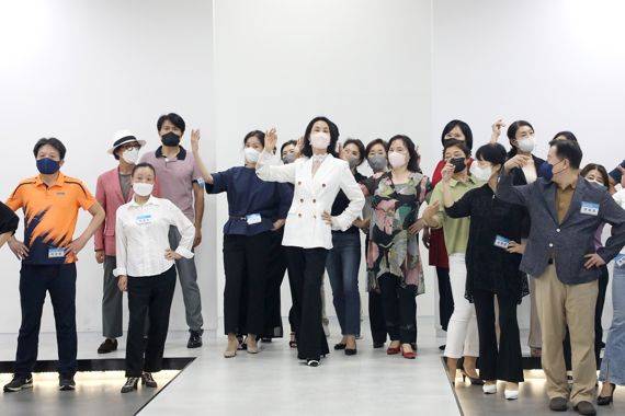 영남이공대가 모델테이너과 실습실에서 '시니어 모델 양성과정 교육'을 성황리에 개최했다. 김동수 모델테이너과 교수(가운데)가 수강생들에게 모델 포즈를 보여주고 있다. 사진=영남이공대 제공