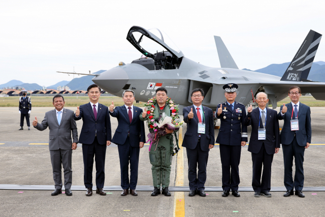 공군 제 52시험평가전대 소속 안준현 중령(가운데)이 2022년 9월 28일 경남 사천 제 3훈련비행단 기지에서 국산 전투기 KF-21의 첫 공개 시험비행을 무사히 마친 뒤 이종섭(왼쪽 세번째) 국방부 장관, 이헌승(왼쪽 다섯번째) 국회 국방위원장 등 국내외 고위관계자 등과 기념사진을 찍고 있다. 사진제공=방사청