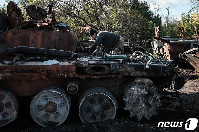 25일(현지시간) 우크라이나 군이 최근 탈환한 하르키우의 이지움에서 러시아 군이 버리고 떠난 탱크를 자원병이 살펴 보고 있다. ⓒ AFP=뉴스1 ⓒ News1 우동명 기자