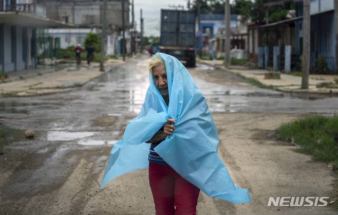 [바타바노=AP/뉴시스] 26일(현지시간) 쿠바 바타바노에서 한 주민이 비닐로 비를 피하고 있다. 열대성 폭풍에서 허리케인으로 세력을 키운 '이언'은 쿠바 서쪽으로 접근하고 있으며 28일경에는 미 플로리다주에 상륙할 것으로 보인다. 2022.09.27.