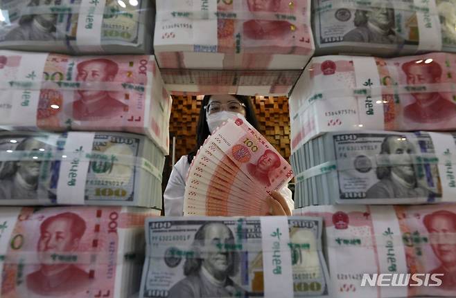 [서울=뉴시스] 이영환 기자 = 2020년 이후 역외 달러·위안 환율이 1달러당 7위안을 돌파한 16일 오후 서울 중구 하나은행 위변조대응센터에서 직원이 달러와 위안화를 선보이고 있다. 2022.09.16. 20hwan@newsis.com