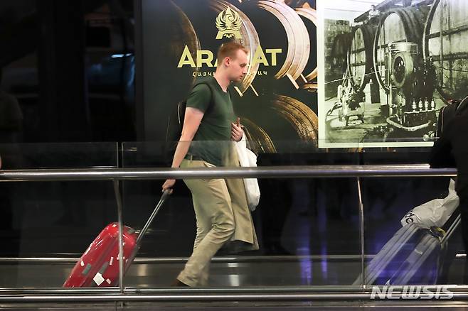 [예레반=AP/뉴시스] 22일(현지시간) 아르메니아 예레반 외곽의 국제 공항에 도착한 러시아 남성이 짐을 끌고 이동하고 있다. 블라디미르 푸틴 러시아 대통령이 예비군 부분 동원령을 내린 지 하루 만에 많은 러시아 남성이 러시아를 떠나는 것으로 알려졌다. 2022.09.23.