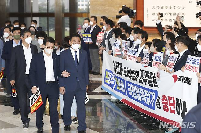 [서울=뉴시스] 최진석 기자 = 국민의힘 정진석 비상대책위원장을 비롯한 의원들이 29일 서울 여의도 국회에서 열린 제400회 국회(정기회) 제09차 본회의에 입장하는 민주당 의원들을 향해 피켓을 들고 있다. (공동취재사진) 2022.09.29. photo@newsis.com