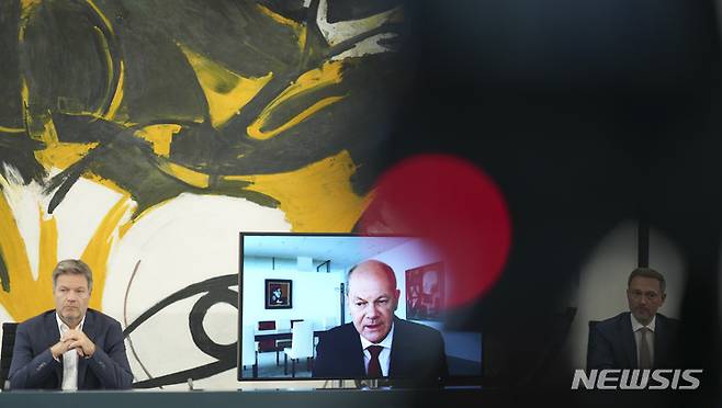 [AP/뉴시스] 29일 독일 총리관저에서 올라프 숄츠 총리(가운데), 로베르트 하벡 경제부총리 및 크리스티안 린드너 재무장관이 에너지 공급에 관한 기자회견을 하고 있다. 숄츠 총리는 코로나19 감염 격리로 화상 출현했다