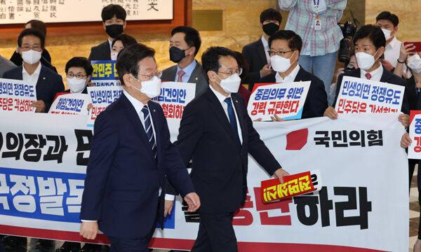 더불어민주당 이재명 대표가 29일 박진 외교부 장관 해임안을 처리하기 위해 국회 본회의장으로 들어갈 때 국민의힘 의원들이 이에 반대하는 피켓 시위를 벌이고 있다. 연합뉴스