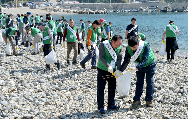 HJ중공업이 태풍으로 해양쓰레기가 유입된 부산 영도구 중리 해변에서 쓰레기를 수거하고 있다./사진제공=HJ중공업