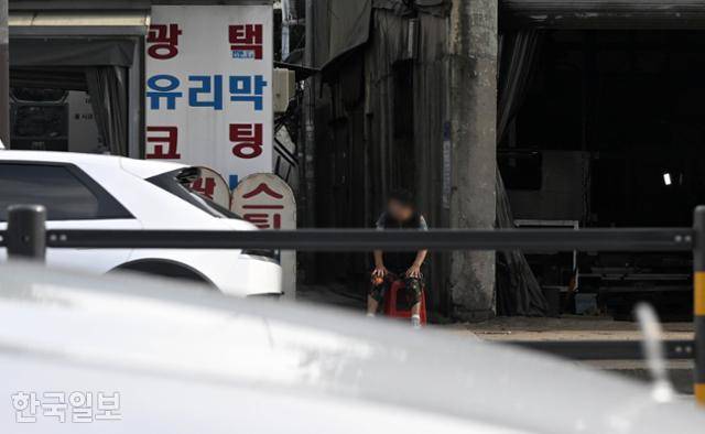 23일 오후 서울 영등포구 영등포동 쪽방촌으로 통하는 좁은 골목 앞에 한 중년 여성이 나와 앉아 있다. '펨푸(호객꾼)'로 불리는데, 쪽방의 성매매 여성과 손님을 연결해 주고 소개료를 챙긴다. 서재훈 기자