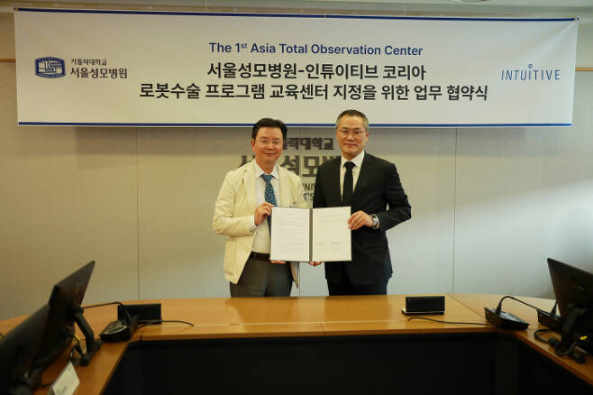 서울성모병원 윤승규 병원장(왼쪽)과 인튜이티브 최용범 한국지사대표가 아시아 최초로 '로봇수술 프로그램 교육센터(Total Observation Center)' 지정을 위한 업무협약을 체결한 후 기념사진을 찍었다.