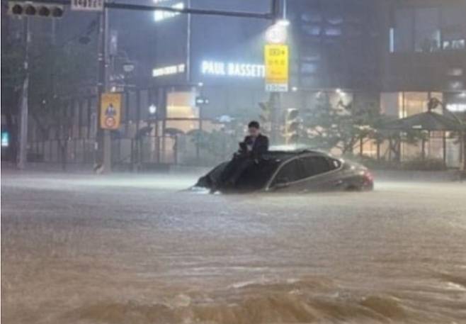 지난 8월 8일 기록적 폭우로 퇴근 중 침수된 차량 위에 올라 구조를 기다렸던 남성. [SNS 갈무리]
