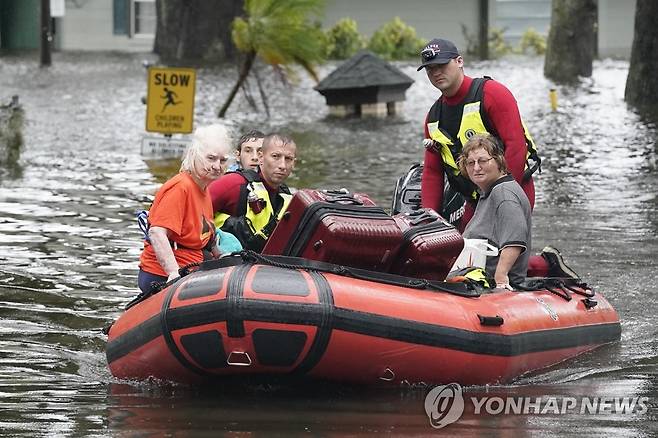 구조된 뒤 보트를 타고 대피하는 플로리다 주민들 (올랜드[미 플로리다주] AP=연합뉴스) 2022년 9월 29일(현지시간) 허리케인 이언이 강타한 플로리다 올랜도에서 주민들이 보트를 타고 대피하고 있다. 2022.10.1