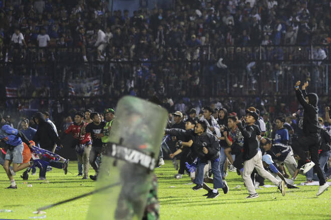 인도네시아 축구팬들이 그라운드에 난입해 폭동을 일으키고 있다. 사진=AP PHOTO