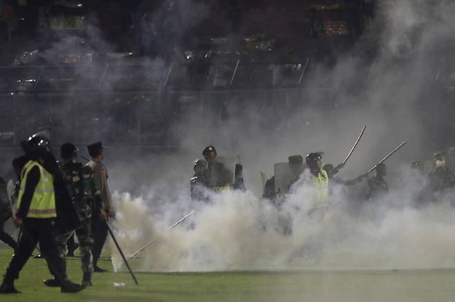 1일 폭동이 발생한 인도네시아 자바의 칸주르한 경기장에서 경찰과 보안요원들 사이로 최루탄 연기가 피어오르고 있다. 자바/AP 연합뉴스
