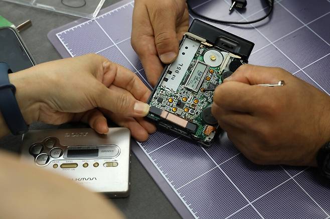 성동공유센터에서 소니 워크맨을 열어서 고장 원인을 살펴보고 있다. 류우종 기자