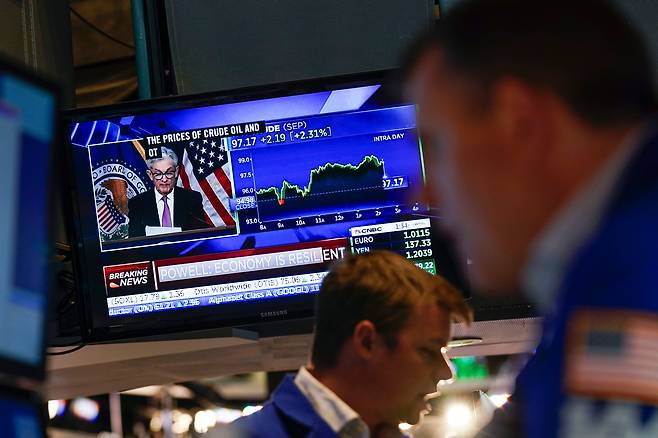 지난달 27일(현지시간) 미국 뉴욕증권거래소(NYSE) 입회장 내 스크린에 제롬 파월 미국 연방준비제도(Fed·연준) 의장의 기자회견 모습이 비치는 가운데 트레이더들이 업무를 처리하고 있다./연합뉴스