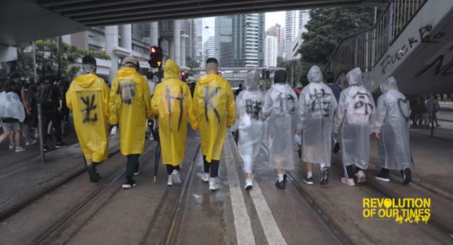 2019년 홍콩 민주화 시위대가 비옷 뒤에 시위 구호인 '광복HK(홍콩), 시대혁명'을 적고선 거리를 거닐고 있다. 명보아트시네마 제공