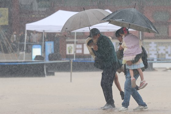 가을비가 내린 3일 오전 서울 종로구 경복궁을 찾은 시민들이 우산을 쓰고 이동하고 있다. 연합뉴스