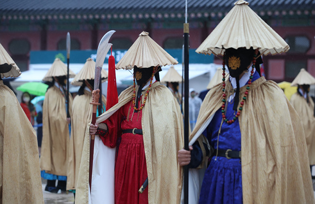 강한 비가 내린 3일 오후 서울 경복궁 흥례문 광장에서 열린 수문장 임명의식 특별행사에서, 참석자들이 전통 우의를 걸친 채 행사를 진행하고 있다. 뉴시스