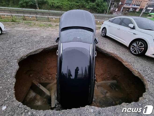 지난해 9월 충남 당진시 시곡동의 한 주차장에서 싱크홀이 발생해 차량 한 대가 지하공간으로 추락해 있다. (당진소방서 제공) /뉴스1