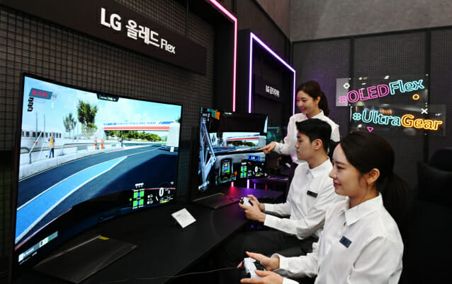 LG전자 모델들이 4일 한국전자전(KES 2022)에서 벤더블(Bendable) 게이밍 올레드 TV 플렉스(FLEX)로 게임을 즐기고 있다. (사진=LG전자)