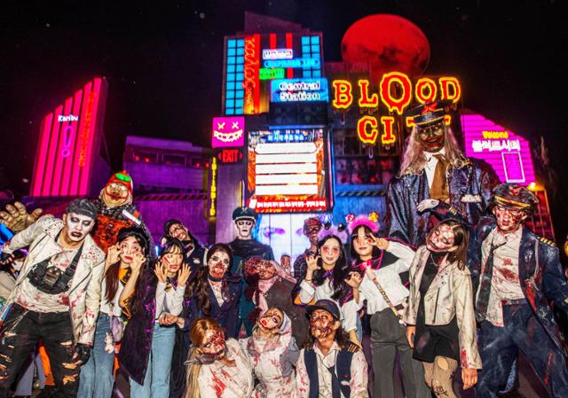 에버랜드 핼러윈 축제의 주무대인 블러드시티를 배경으로 출연 좀비들과 관람객이 기념사진을 찍고 있다. 에버랜드 제공