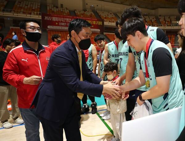 페퍼저축은행 김동언단장과 김형실감독이 남자클럽부에서 우승을 차지한 목포하나클럽 선수들에게 메달을 걸어주는 모습.