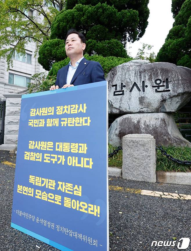 송갑석 더불어민주당 윤석열 정부 정치탄압대책위원회 부위원장이 4일 오전 서울 종로구 감사원 앞에서 ‘감사원의 문재인 전 대통령 조사’에 항의하는 1인 피켓 시위를 하고 있다. 민주당 정치탄압대책위 소속 의원들은 이날부터 감사원의 문 전 대통령 조사 시도가 부당하는 것을 알리기 위해 릴레이로 1인 시위를 벌이겠다고 밝혔다. 2022.10.4/뉴스1 ⓒ News1 국회사진취재단