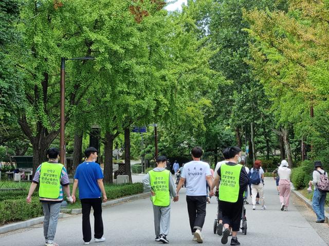 서울의 한 공원에서 발달장애인 평생교육센터를 다니는 청년들과 교사들이 손을 잡고 산책을 하고 있다. 학령기가 지난 성인 발달장애인들은 갈 곳이 없다. 그나마 서울시는 25개 전 자치구(중구는 예정)에 발달장애인 평생교육센터 하나씩은 둔 상태지만, 부산만 봐도 올해 3월에야 첫 센터가 개소했다. 최나실 기자