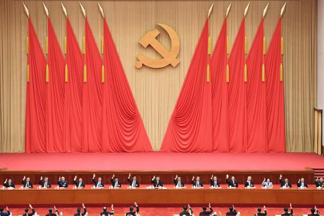 시진핑(가운데) 중국 국가주석이 지난해 6월 베이징에서 개막한 공산당 19기 중앙위원회 6차 전체회의(6중전회)에 참석해 손을 들어 안건을 의결하고 있다. 베이징=AP 뉴시스