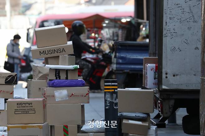 2021년 11월16일 서울 종로구 젊음의 거리에서 쌓여있는 택배 사이로 오토바이가 지나가고 있다. 경향신문 자료사진