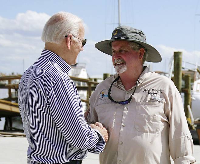 조 바이든 미 대통령(왼쪽)이 5일(현지시간) 허리케인 ‘이언’의 피해를 입은 플로리다를 찾아 포트 마이어스 비치 시장 레이 머피와 악수하고 있다. AP연합뉴스
