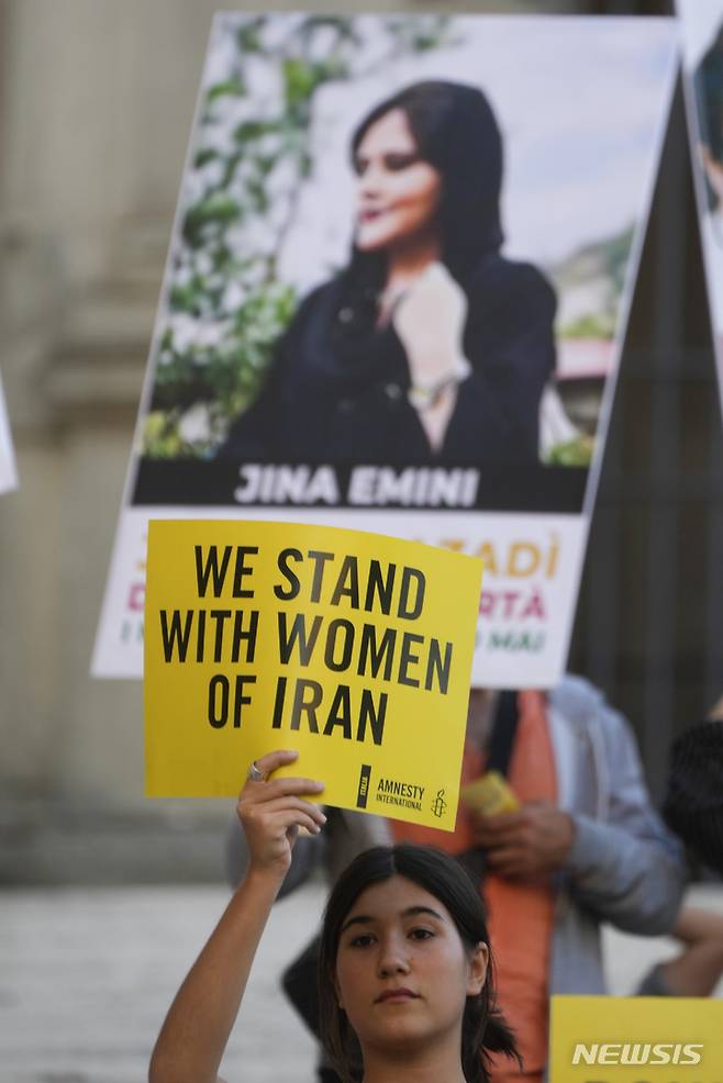 [로마=AP/뉴시스] 국제엠네스티 활동가들이 5일(현지시간) 이탈리아 로마 카피톨 언덕에 앉아 "우리는 이란의 여성과 함께한다"고 적힌 문구를 들고 시위대와 연대하고 있다. 천 명이 넘는 이란인들은 2주 동안 히잡 미착용으로 이란 도덕 경찰에 구금된 마샤 아미니(22)의 죽음에 항의하기 위해 거리로 나서고 있다. 2022.10.06.