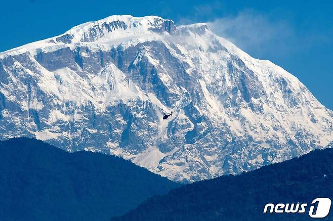 2020년 1월22일 카트만두에서 서쪽으로 약 200km 떨어진 포카라시 안나푸르나 산맥 앞에서 헬기가 구조대와 함께 비행하고 있다. 2022.01.21/news1 ⓒ AFP=뉴스1 ⓒ News1 김민수 기자
