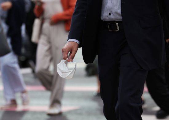 실외 마스크 착용 의무가 전면 해제된 지난달 26일 오전 광화문네거리를 지나는 출근길 시민이 마스크를 손에 쥔 채 걸어가고 있다. [이미지출처=연합뉴스]