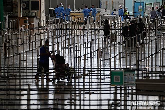 [홍콩=AP/뉴시스] 23일 홍콩 국제공항 입국장에서 승객들이 격리 호텔로 향하는 버스를 기다리고 있다. 존 리 홍콩 행정장관은 오는 26일부터 홍콩 입국자에 대한 호텔 격리 규정을 폐지한다고 밝혔다. 2022.09.23.