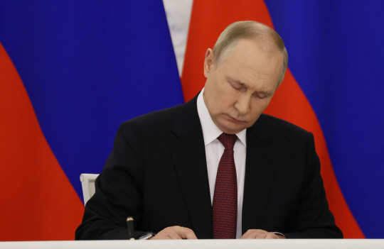 블라디미르 푸틴 러시아 대통령이 지난 달 30일 모스코바 크렘린궁에서 우크라이나 점령지 4곳을 러시아에 병합하는 문서에 서명하고 있다. AP·연합뉴스