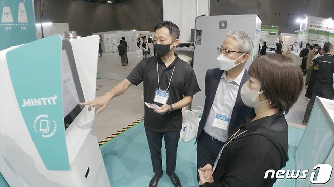 지난 6일부터 8일 일본 아이치현 국제전시장에서 열린 ‘SDGs 아이치(Aichi) 엑스포 2022’에서 현장 담당자가 중고폰 매입 기기 ‘민팃(MINTIT)’ 기능을 설명하고 있다. (SK네트웍스 제공)