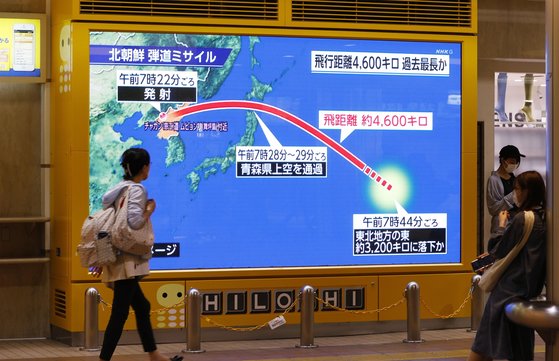 지난 4일 일본 도쿄에서 시민들이 북한의 미사일 발사 소식이 흘러나오는 대형 모니터 앞을 지나고 있다. AP=연합뉴스