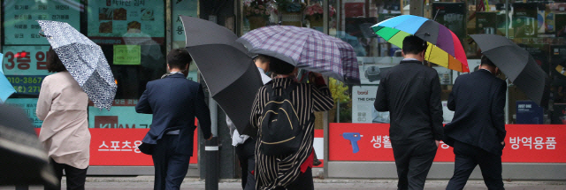 ▲ 시민들이 우산으로 비바람을 막으며 걸어가고 있는 모습. 연합뉴스