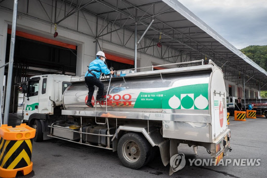지난 9월 14일 서울우유 양주 신공장에서 안전장비를 착용한 작업자가 목장에서 가져온 우유의 샘플을 채취하고 있다. 연합뉴스